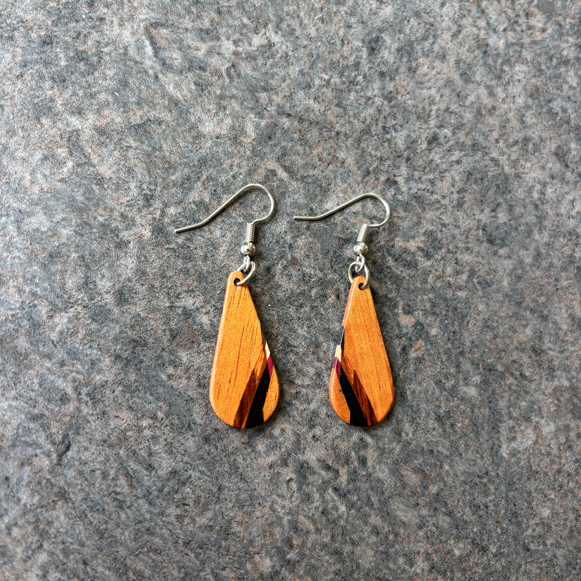 Koa Wood earrings on a textured gray surface