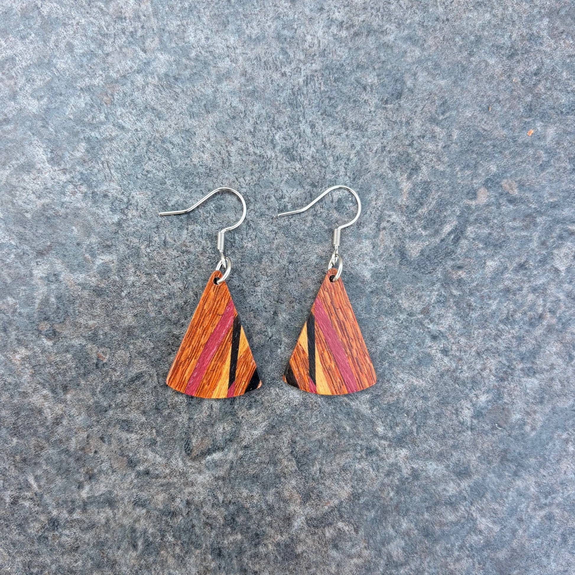 Lacewood triangle earrings on a gray surface