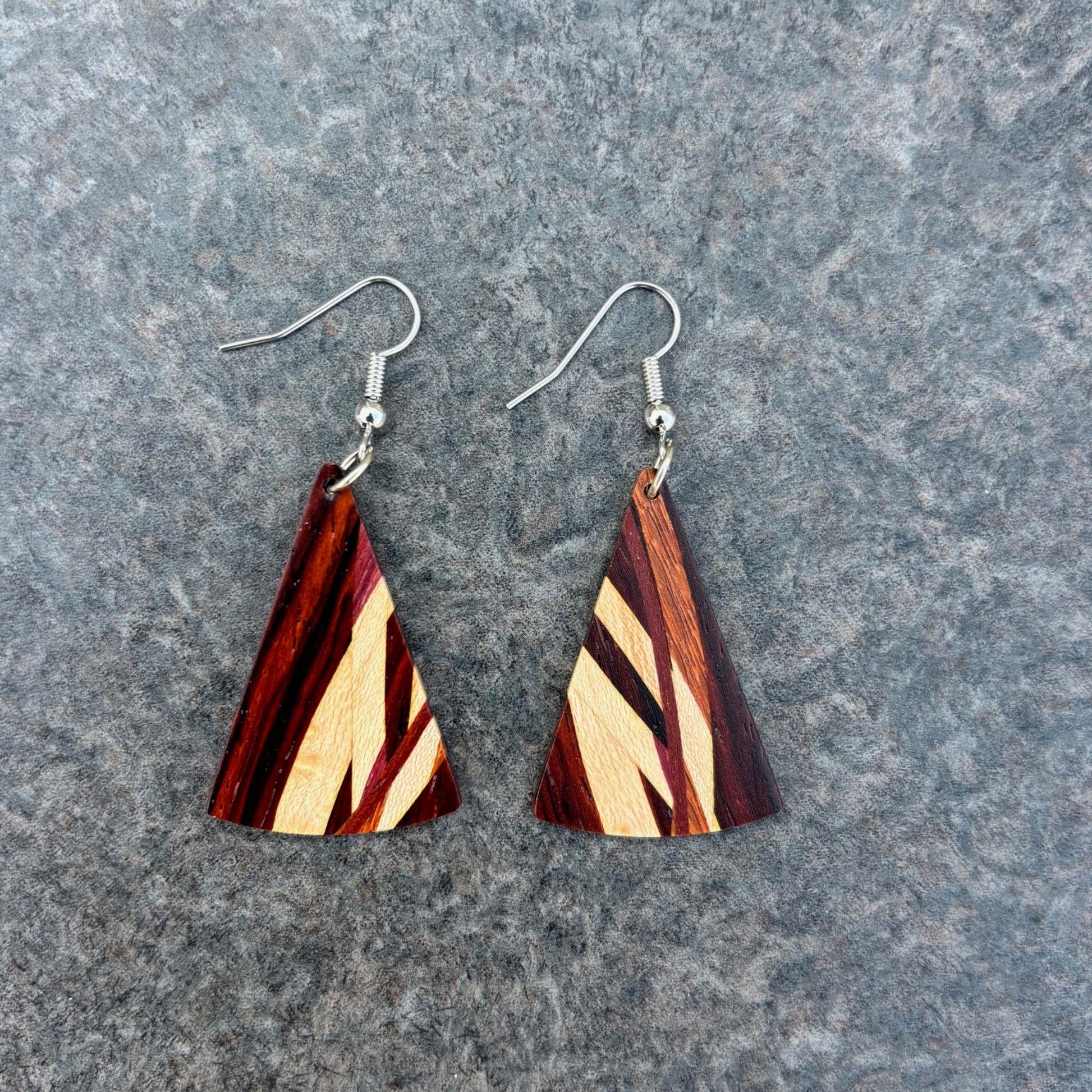 Wooden triangle earrings on a gray surface