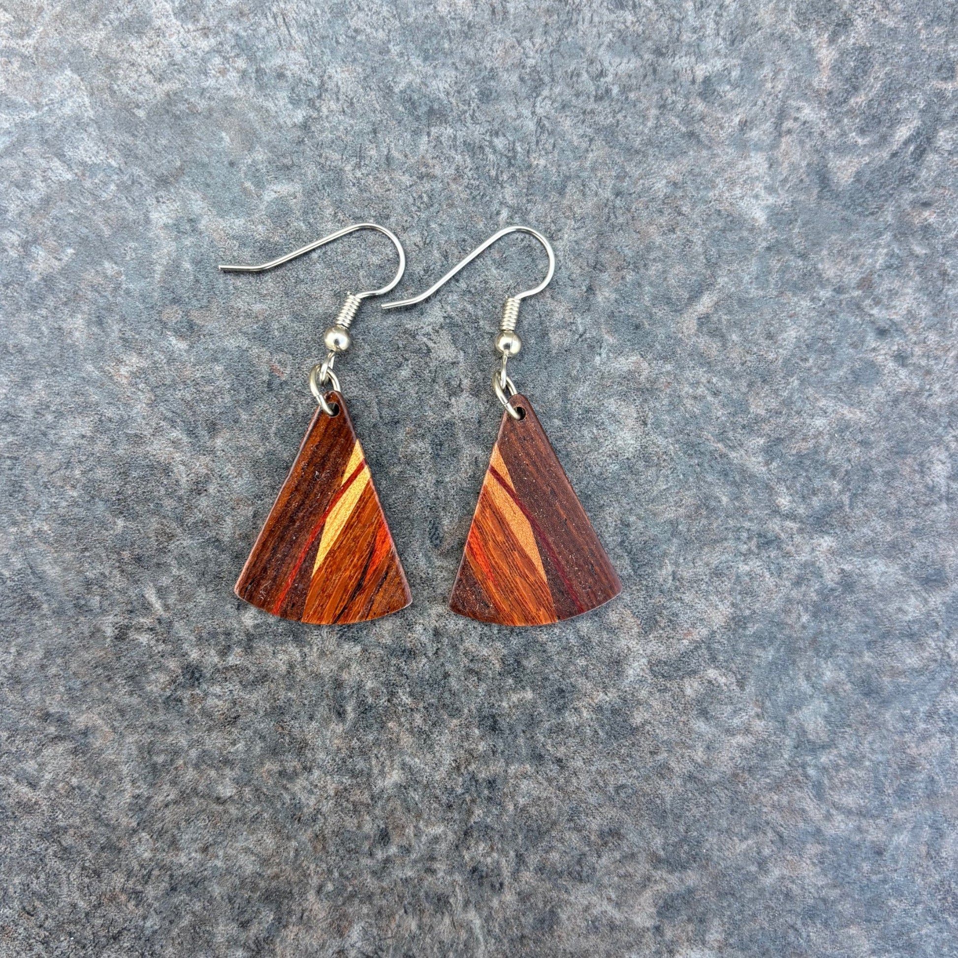 Wooden triangle earrings on a gray surface