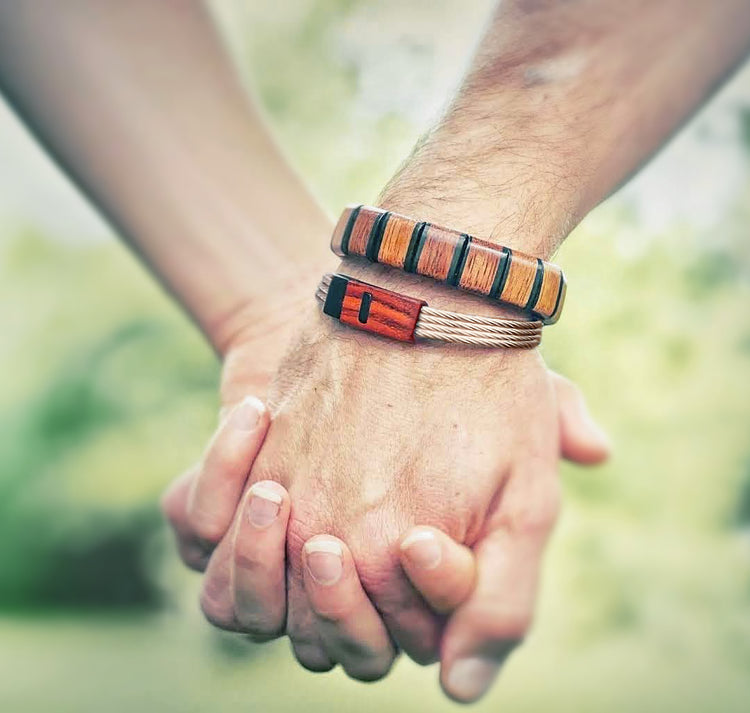couple holding hands man wearing wooden bead bracelet and mens wood bracelet with stainless steel band made by Davin & Kesler